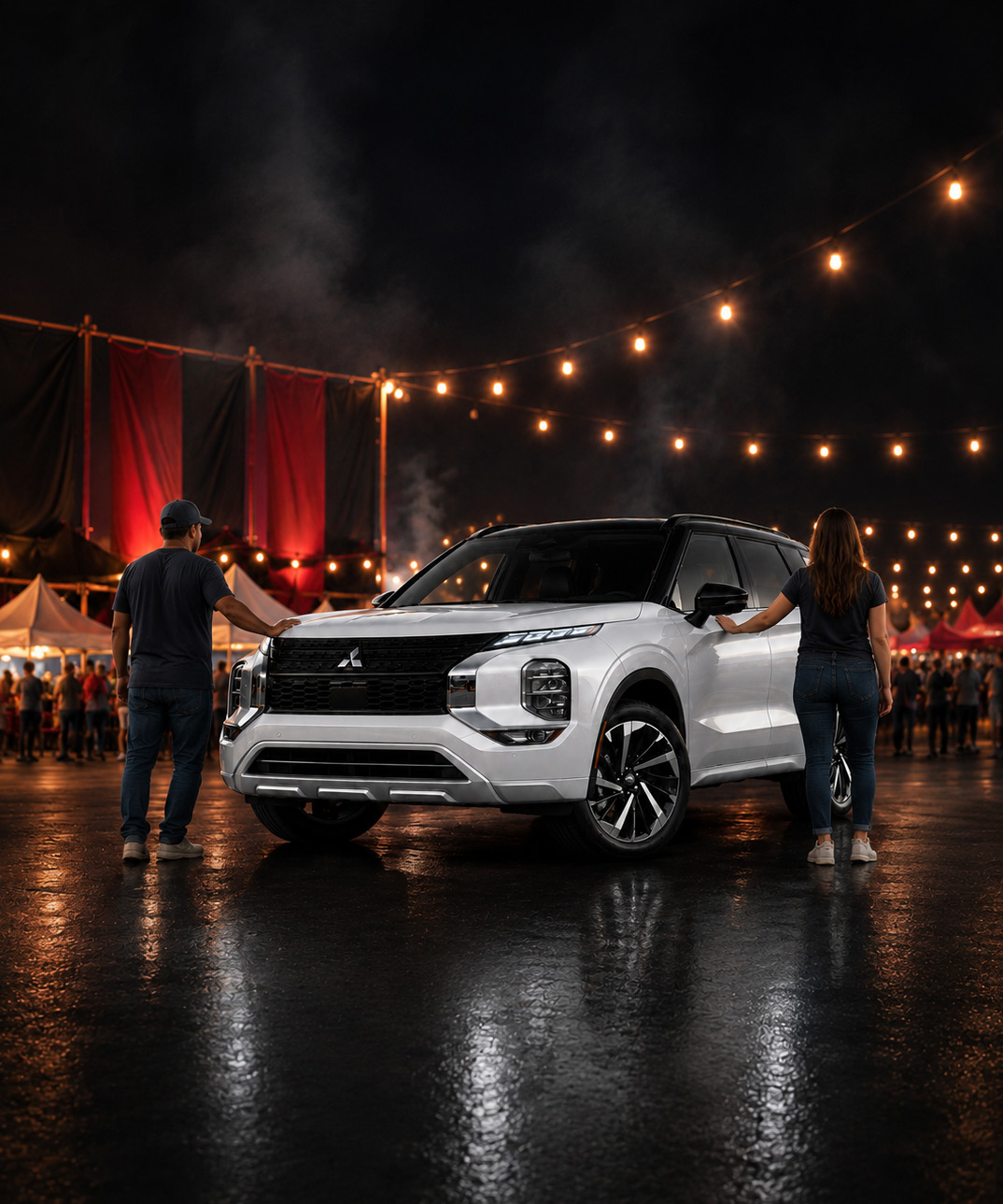 Two people touching a white Mitsubishi SUV at a night rib festival